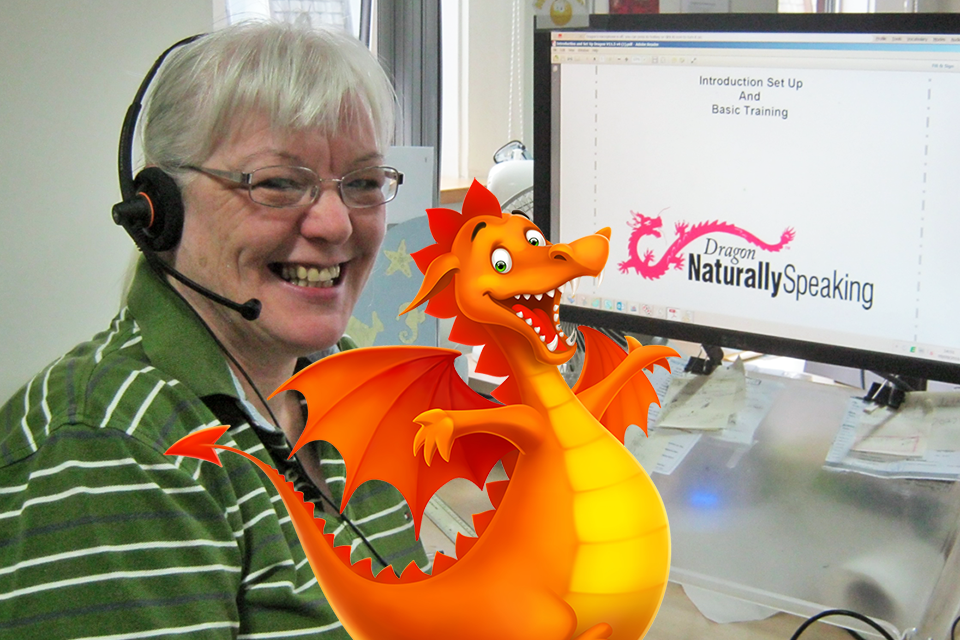 Wendy Hayton sitting at a computer screen displaying DRAGON software, with a cartoon dragon superimposed.