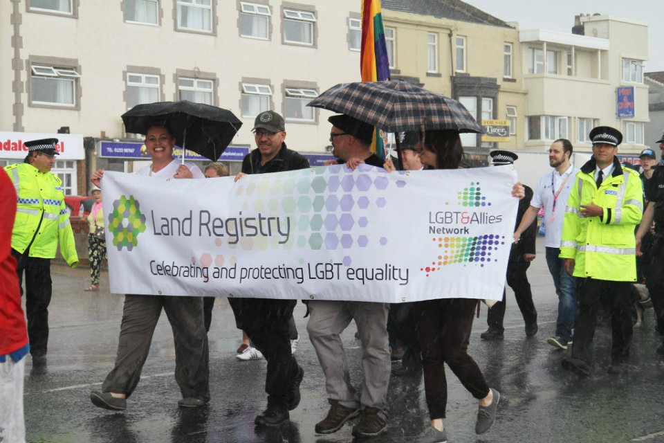 Emma and her colleagues walking behind a Land Registry banner at Blackpool Pride.