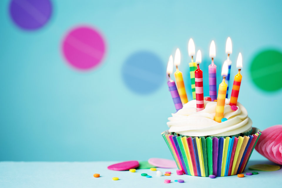 A cup cake with lit candles.