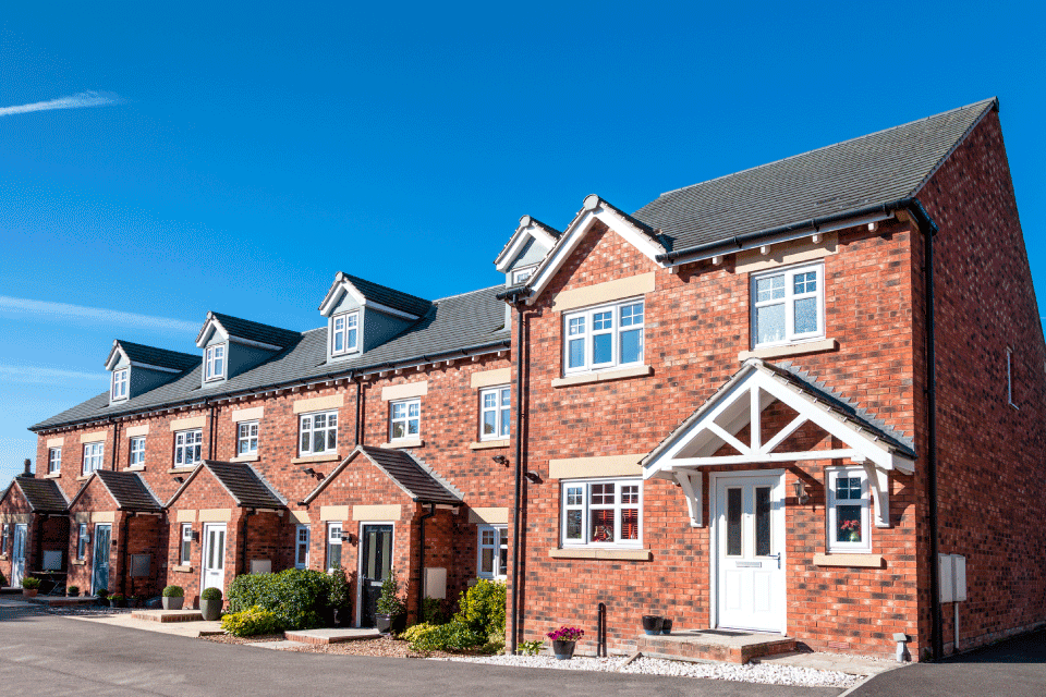 Row of contemporary terraced houses in brick with sloping roofs and dormer windows